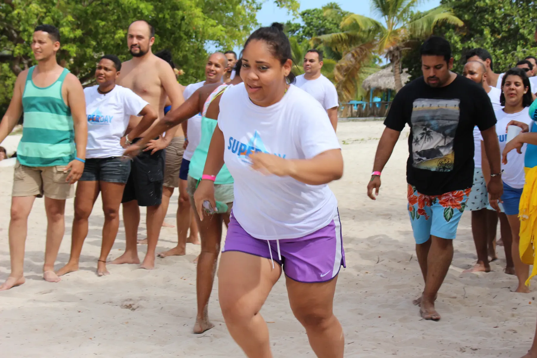 Colaboradores de call center en una carrera de relevos en la arena durante el SUPERDAY en Isla Saona