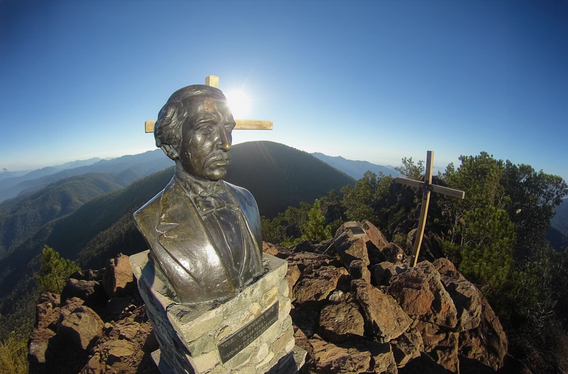 Bronze bust of Juan Pablo Duarte with a wooden cross at Pico Duarte summit in the Dominican Republic.