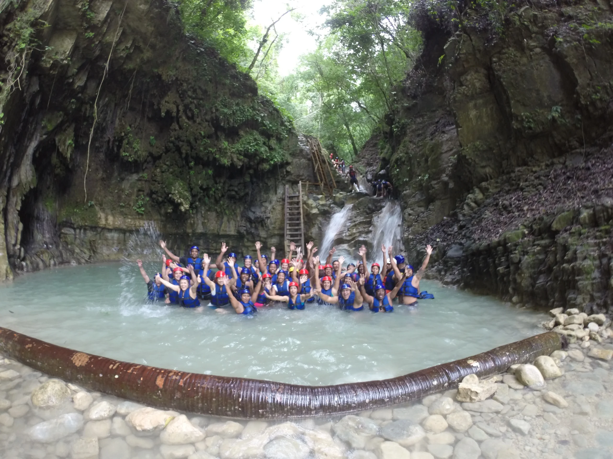 Large group of tourists celebrating in the water at the 27 Waterfalls of Damajagua.