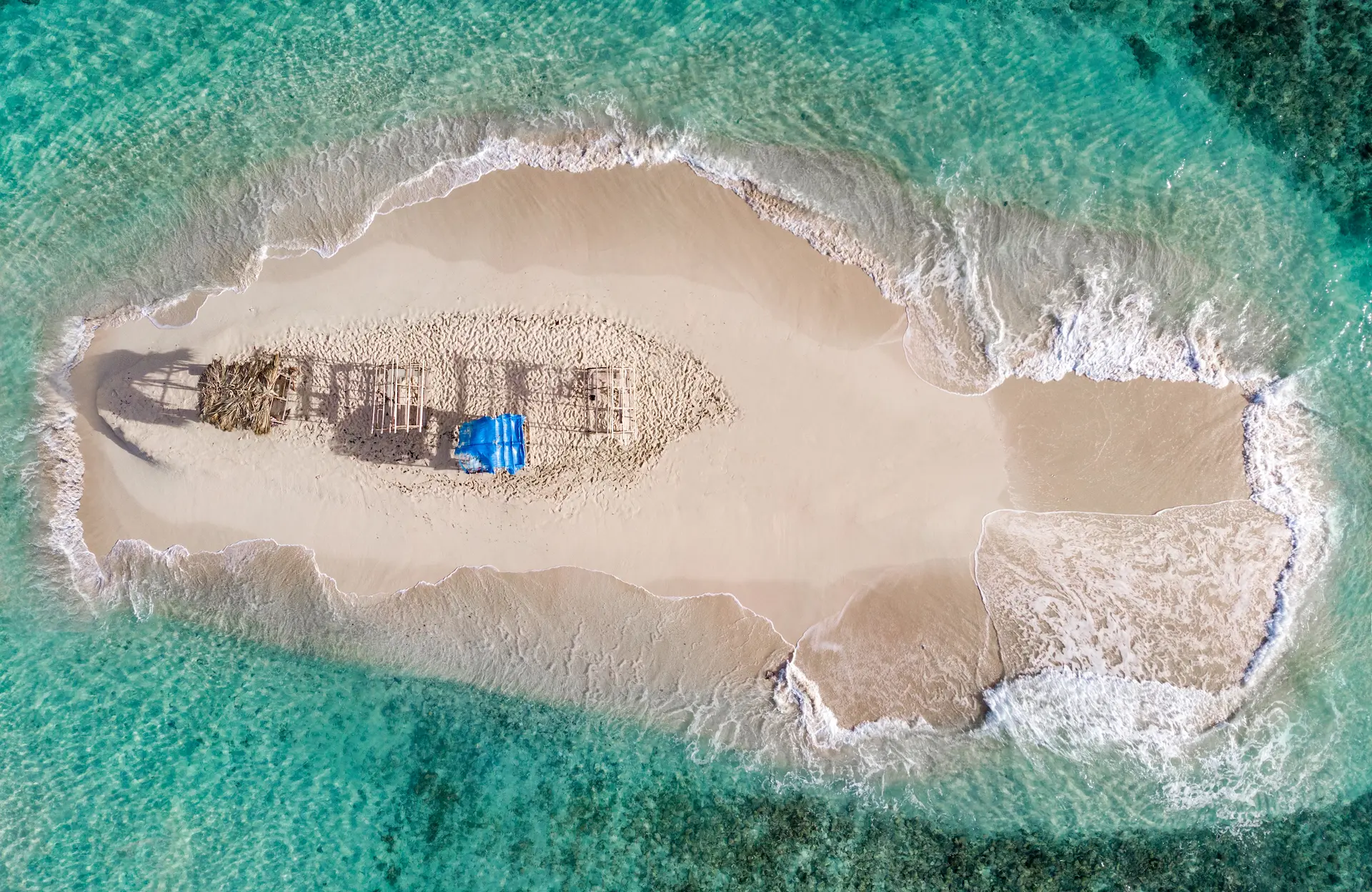 Top view of Cayo Arena sandbank with rustic huts and turquoise waters in Monte Cristi, Dominican Republic