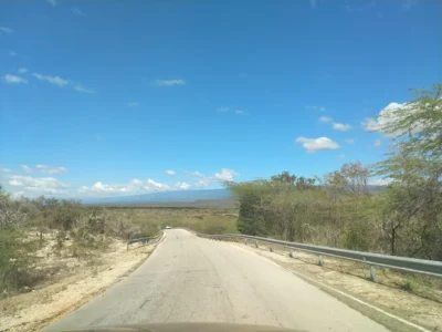 Scenic road leading to Pedernales in the Dominican Republic, surrounded by dry forest and mountains.