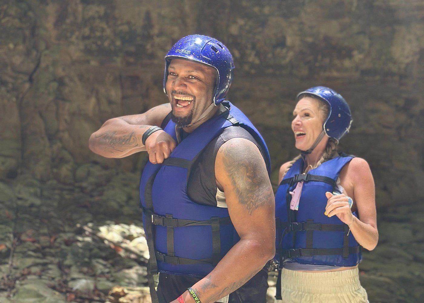 Smiling adventurers in helmets enjoying the waterfalls at Damajagua.