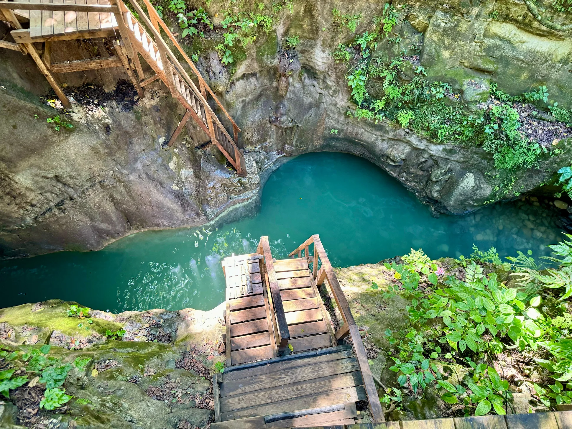 Wooden stairs leading down to a natural pool at the 27 Waterfalls of Damajagua.