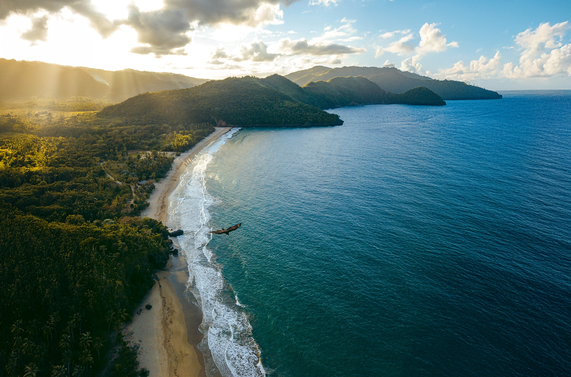 Aerial view of El Valle Beach surrounded by lush mountains in Samaná