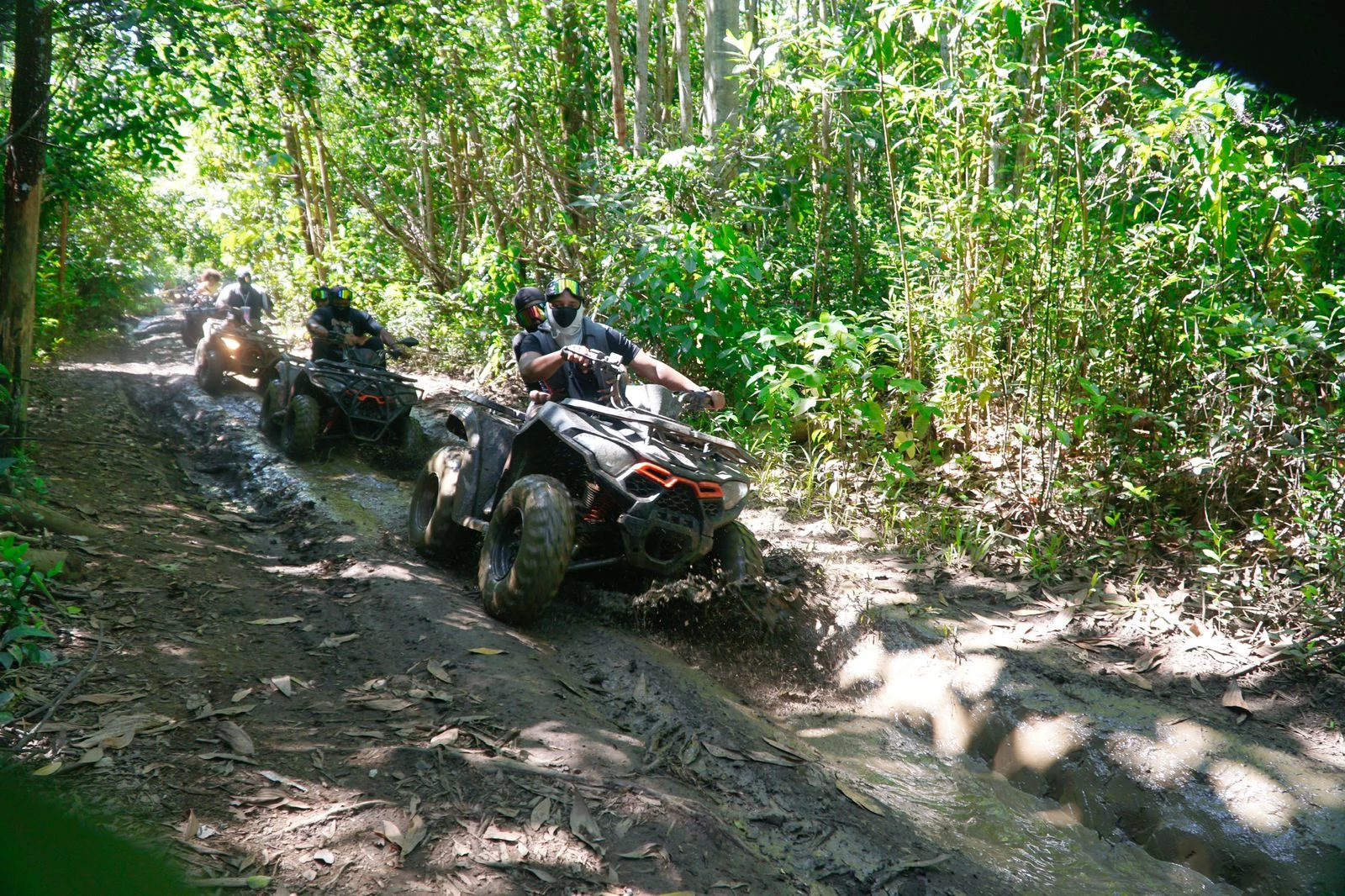 Group of travelers riding ATVs through muddy forest trails in Comatillo, Bayaguana.