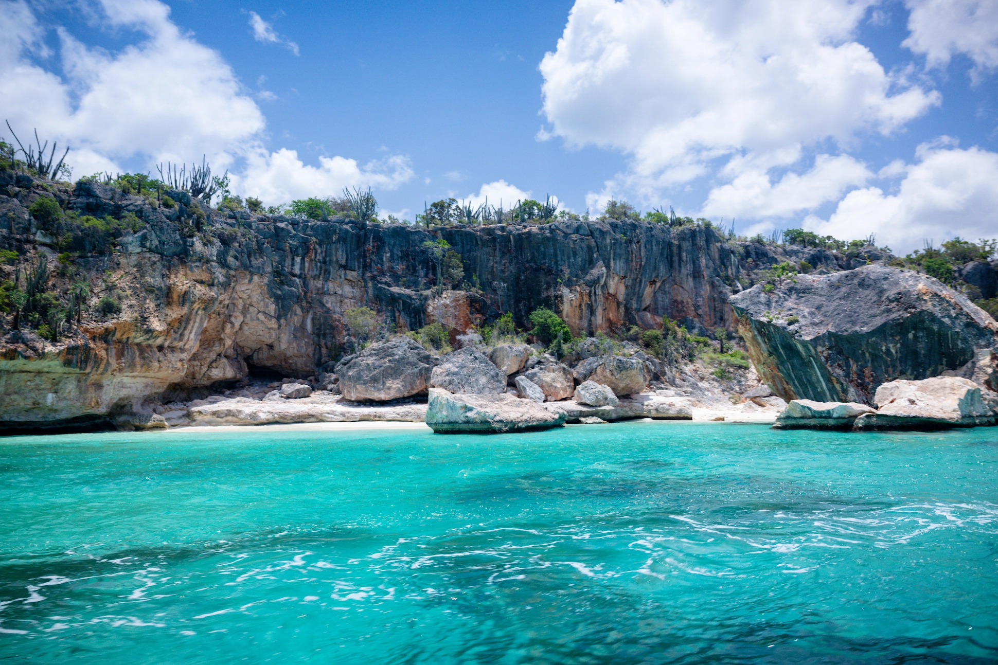 Rocky cliffs with cactus vegetation overlooking the turquoise Caribbean waters at Bahía de las Águilas, Dominican Republic.