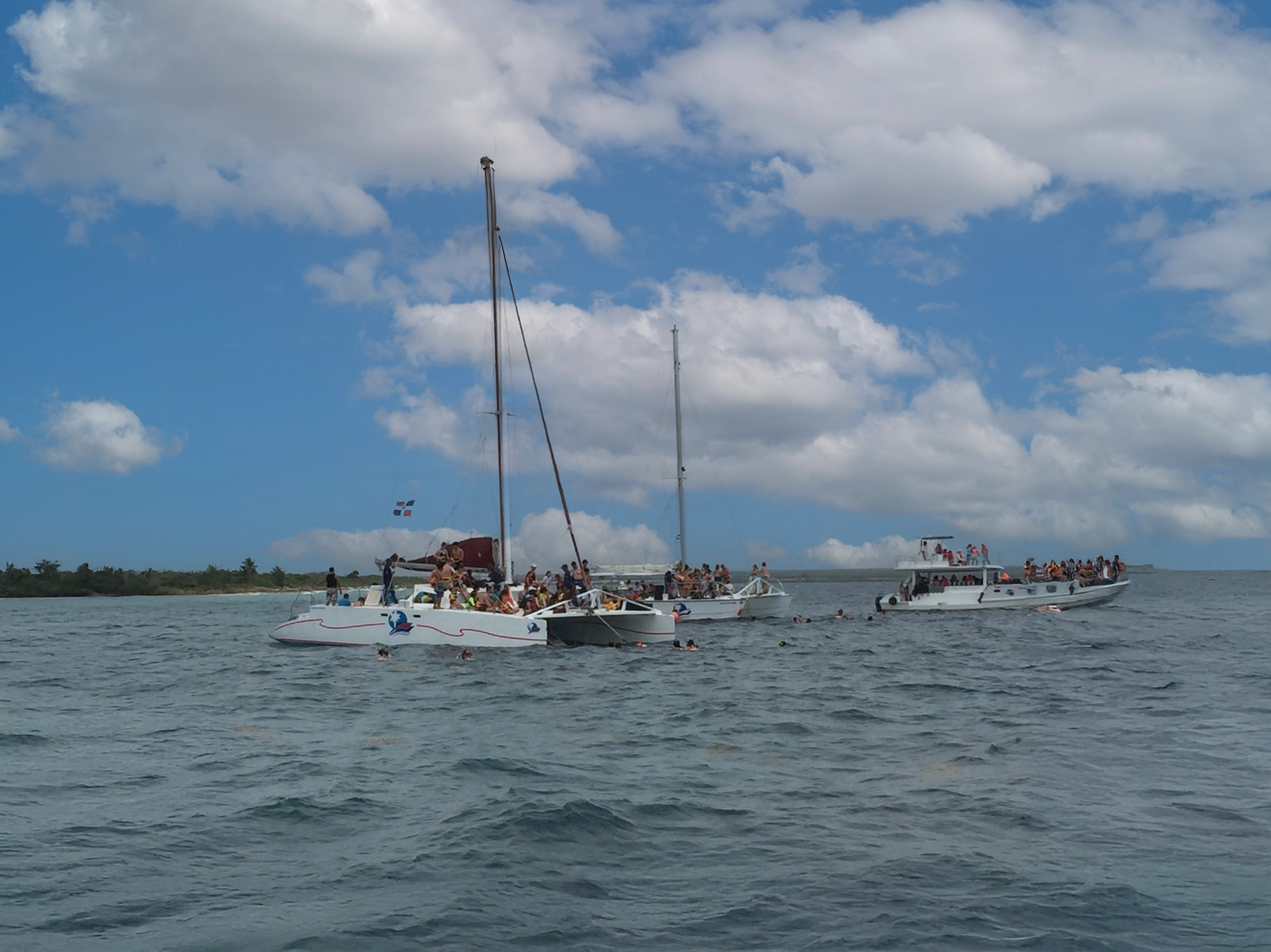 Boats anchored near Catalina Island while travelers snorkel in clear Caribbean waters