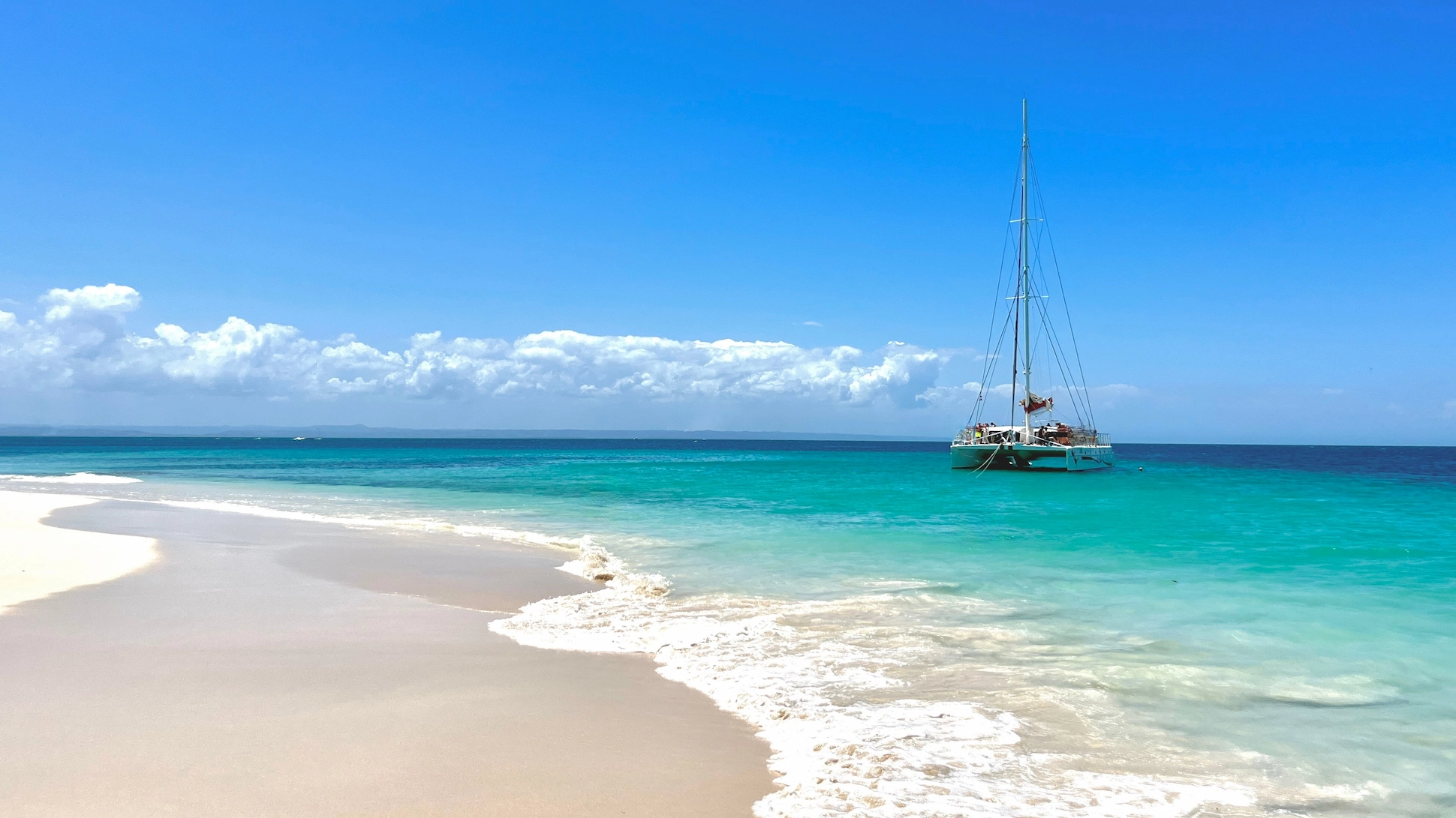 Catamaran anchored at the turquoise waters of Cayo Levantado beach.
