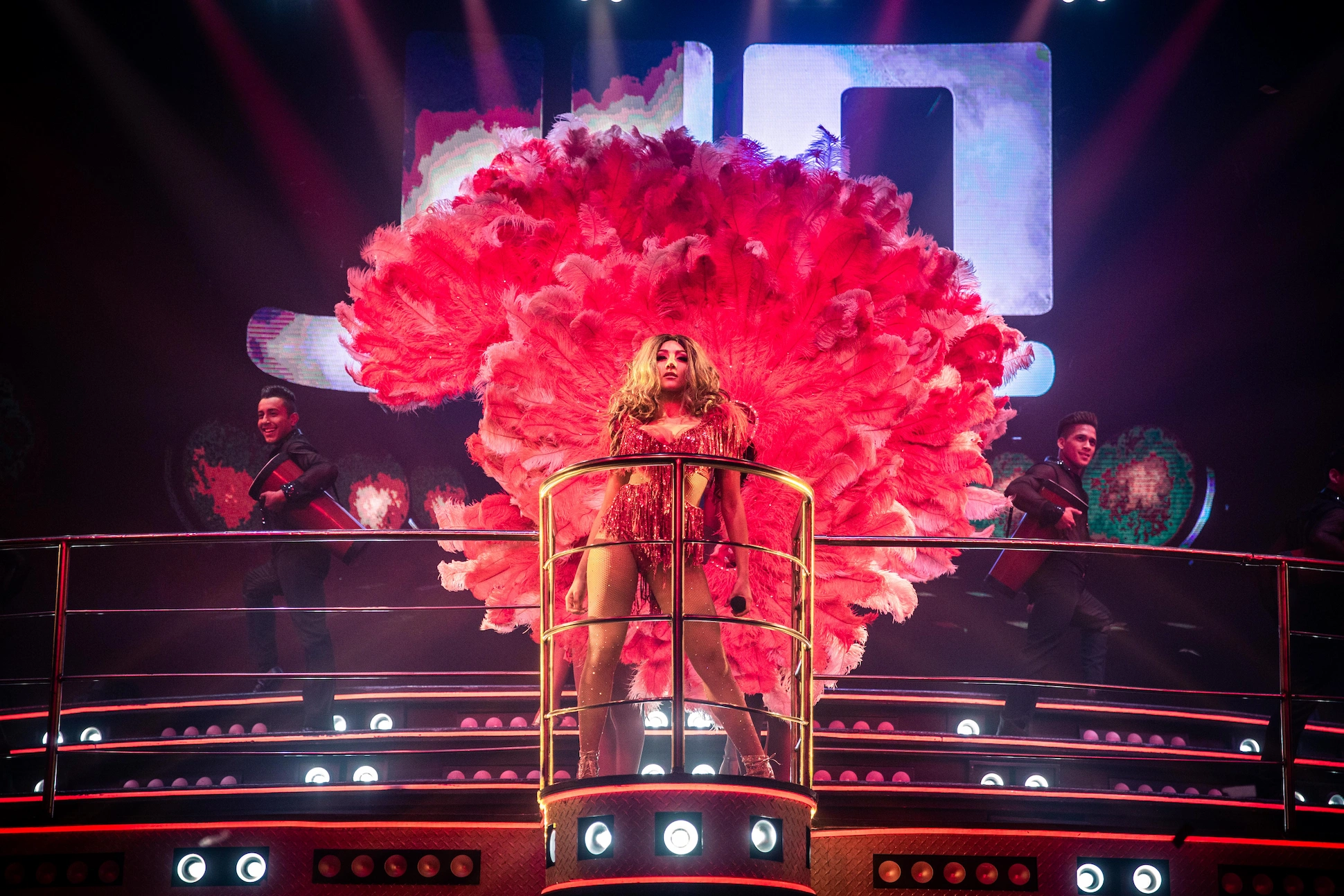 Performer with vibrant feathers on stage at Coco Bongo Punta Cana with open bar and hotel pick up