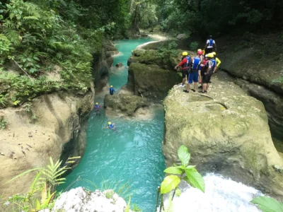 Travelers swimming and hiking along turquoise pools in Cola de Pato canyon