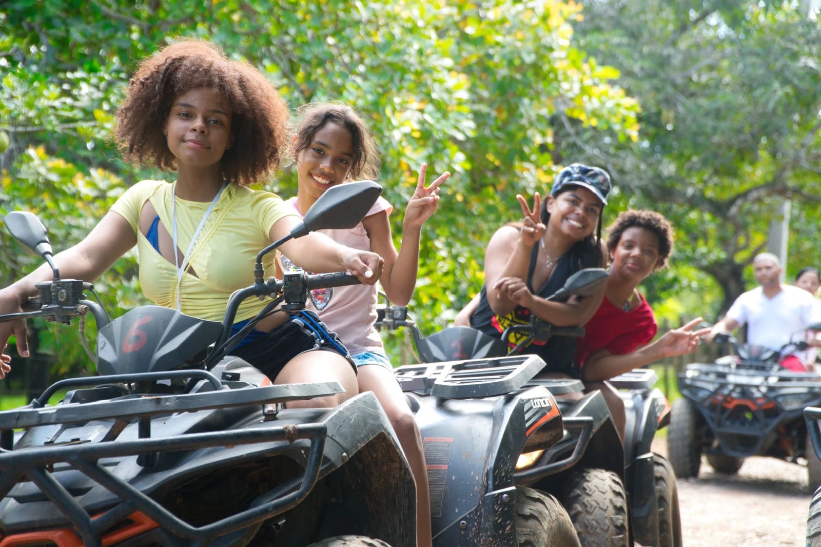 Family and friends smiling while riding ATVs in Comatillo off-road tour.