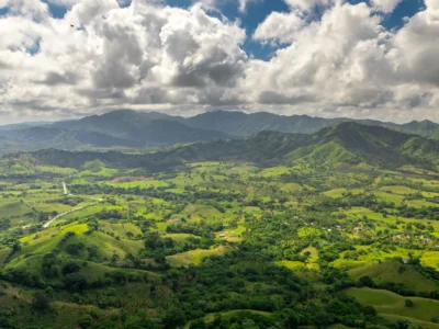 Panoramic view of green mountains and valleys in the Dominican Republic under cloudy skies.