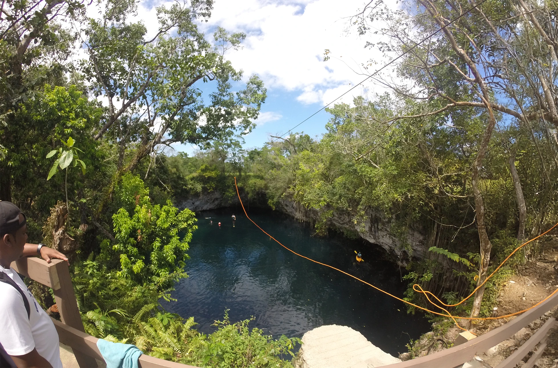 Travelers ziplining into Laguna Dudú cenote
