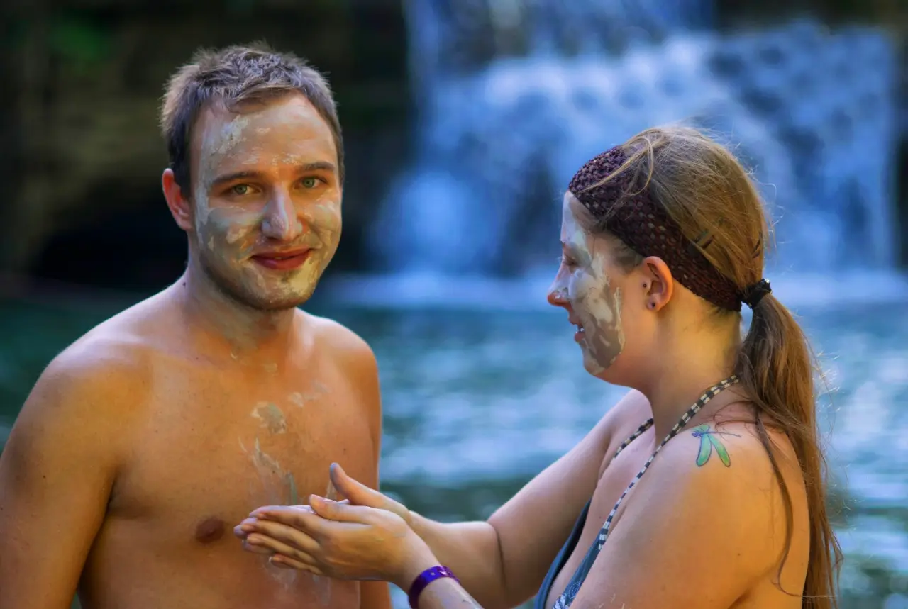 Couple enjoying a natural mud bath at Salto de Yanigua waterfall in Hato Mayor, Dominican Republic