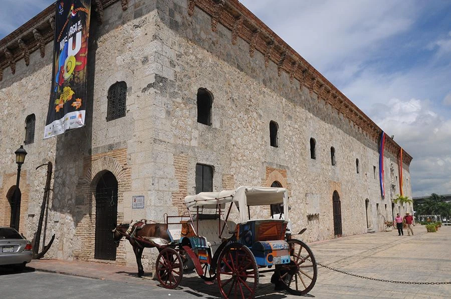 Stone facade of Museo de las Casas Reales with a traditional carriage in Santo Domingo Colonial Zone Dominican Republic