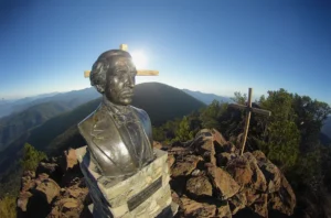 Bronze bust of Juan Pablo Duarte with a wooden cross at Pico Duarte summit in the Dominican Republic.