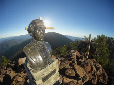 Bronze bust of Juan Pablo Duarte with a wooden cross at Pico Duarte summit in the Dominican Republic.