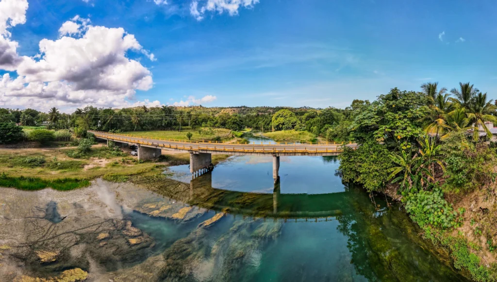 Panoramic view of Río Jamao with a bridge surrounded by lush greenery in Jamao al Norte, Dominican Republic.
