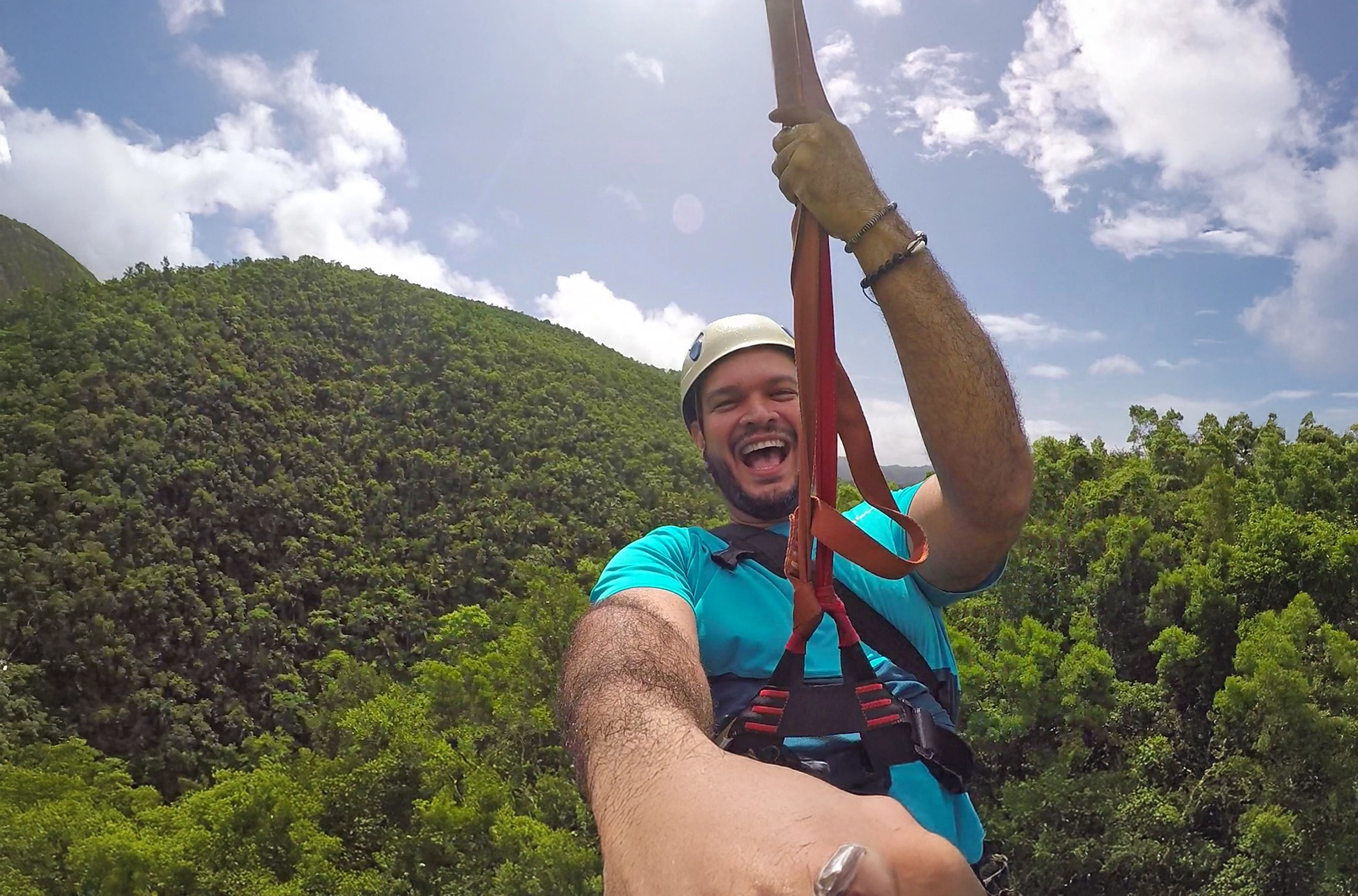 Smiling tourist enjoying the Samaná Zipline ride over the tropical forest.