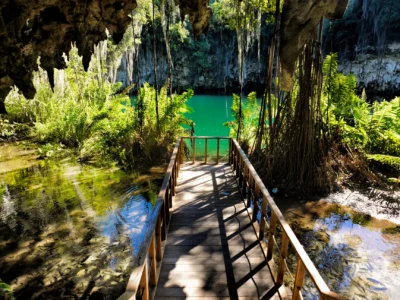 Scenic view of Zaramagullones lake at Los Tres Ojos in Santo Domingo, surrounded by lush tropical vegetation.